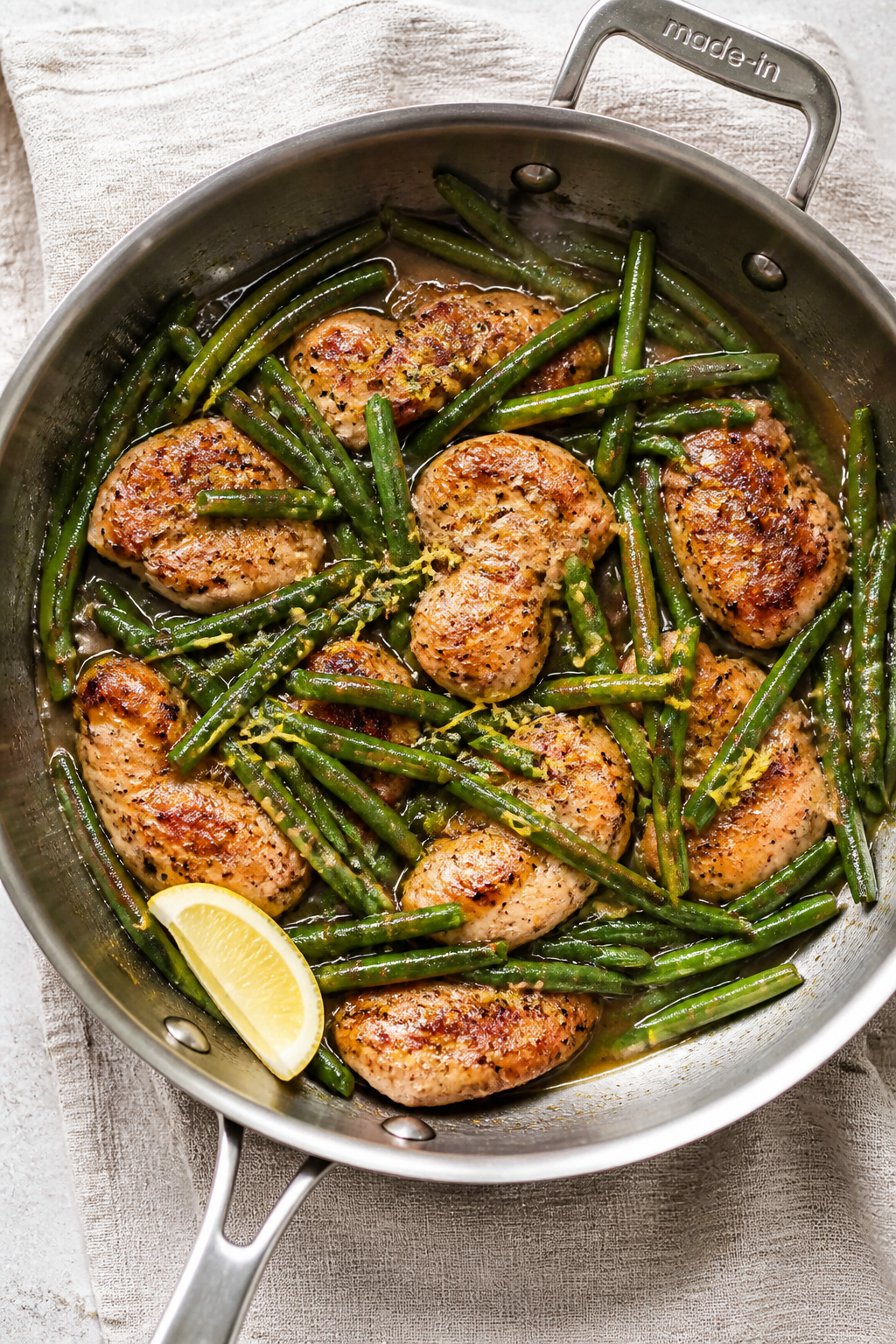 Cooking process: Overhead shot of green beans being tossed in the reduced garlic-butter-chicken-brot
