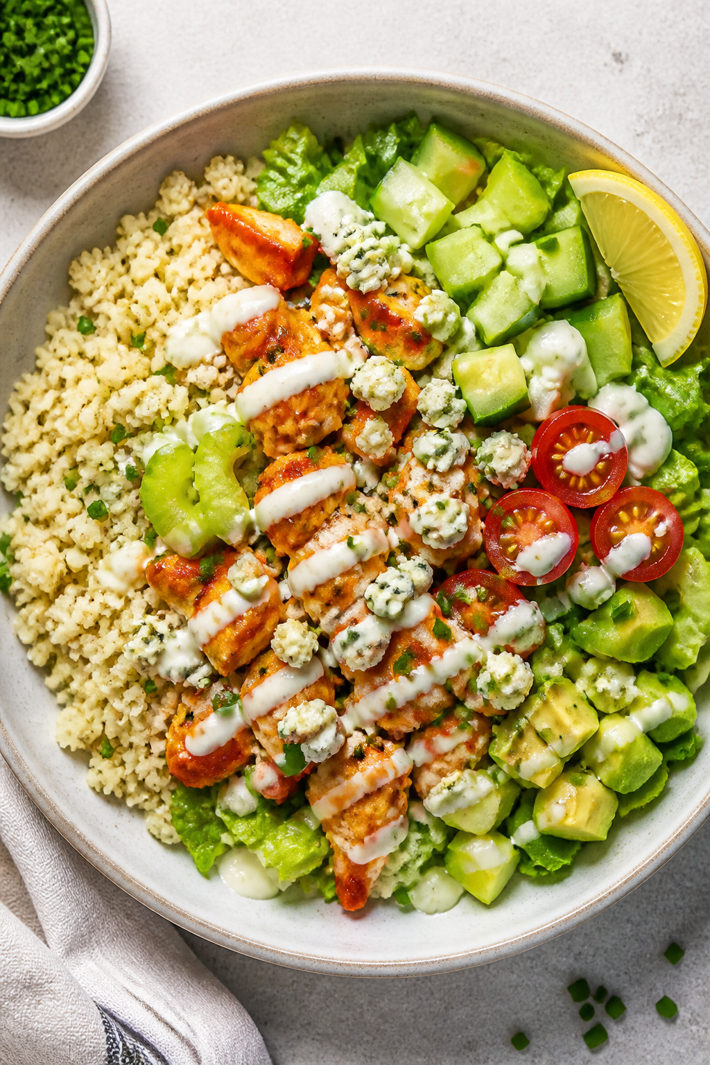 Overhead “tasty top view” assembly shot: Keto Buffalo Ranch Chicken Bowls arranged on a neutral