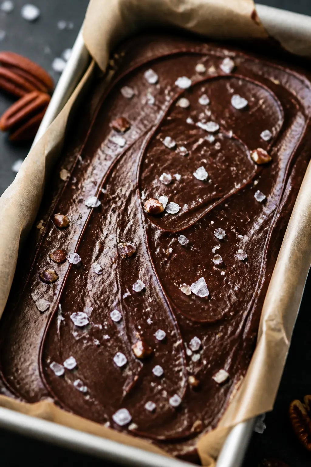 Close-up detail: A glossy slab of chilled High Protein Keto Fudge set in a parchment-lined loaf pan,