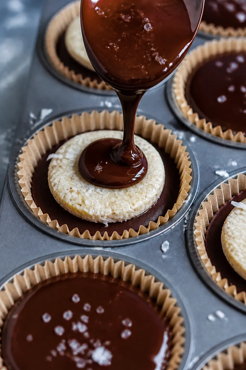 Close-up process shot: freshly assembled Keto Chocolate Coconut Protein Cups in a lined muffin tin,