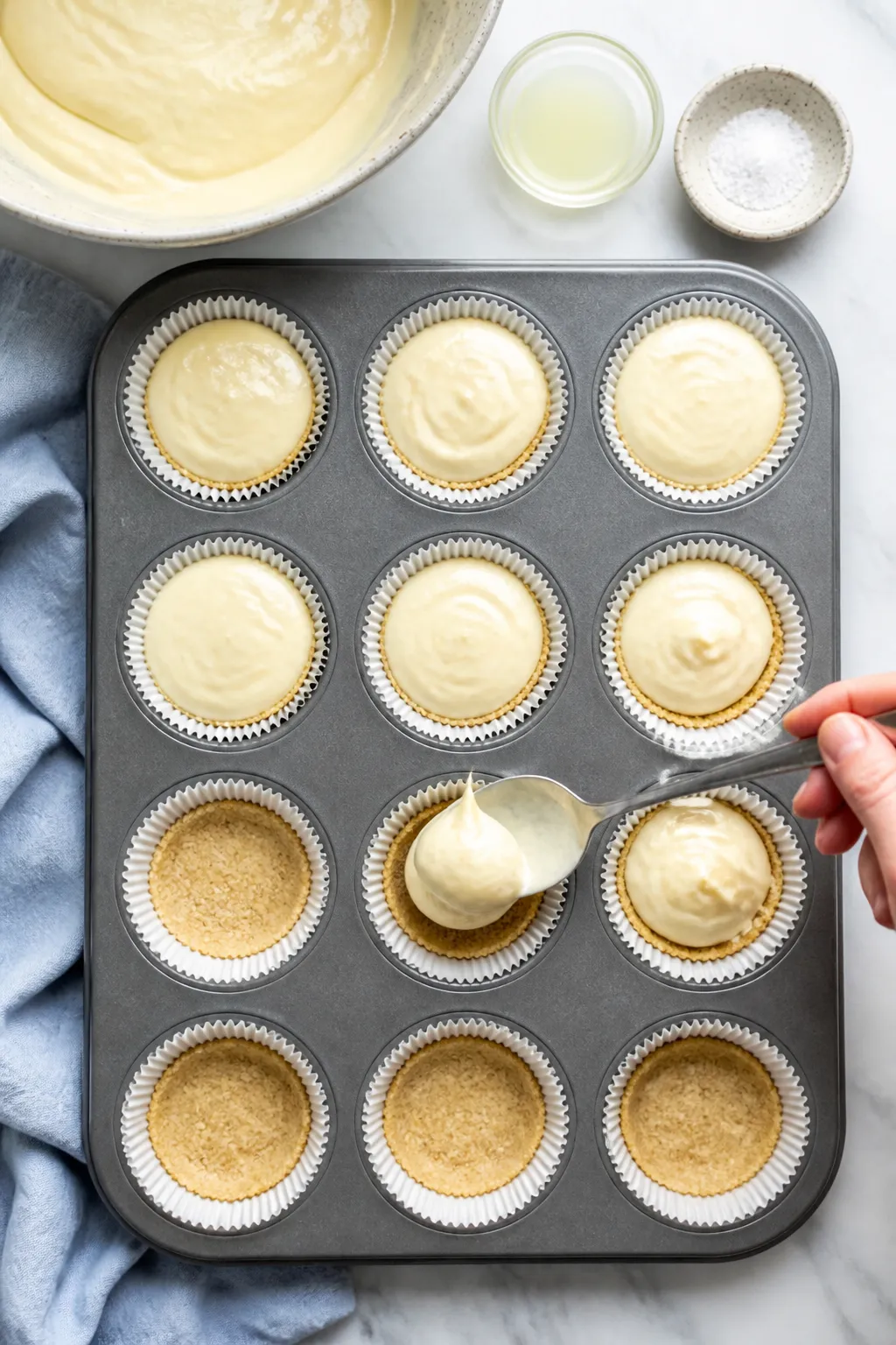 Cooking process: Overhead shot of the prepared filling being spooned into lined muffin cups with a t